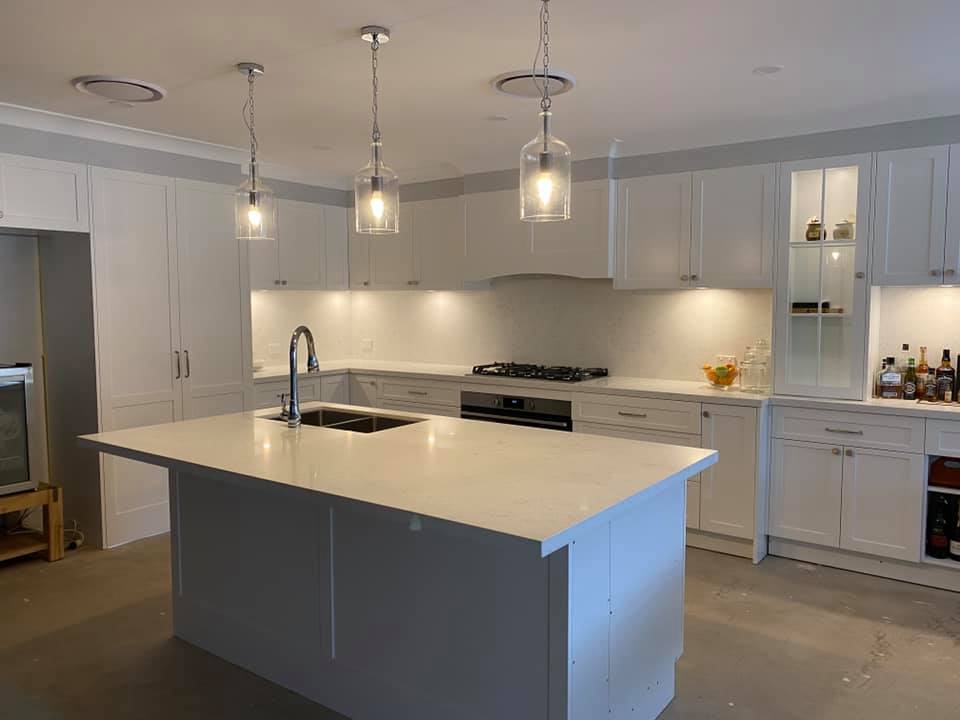Pendant lights hanging over new island bench in kitchen.
